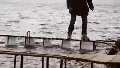 一个人在狭窄冰冷的码头上危险地行走